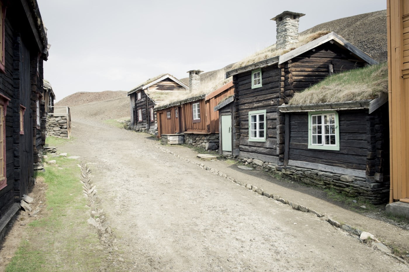 Bilde av en gammel gate på Røros, med gamle små tømmerhus.